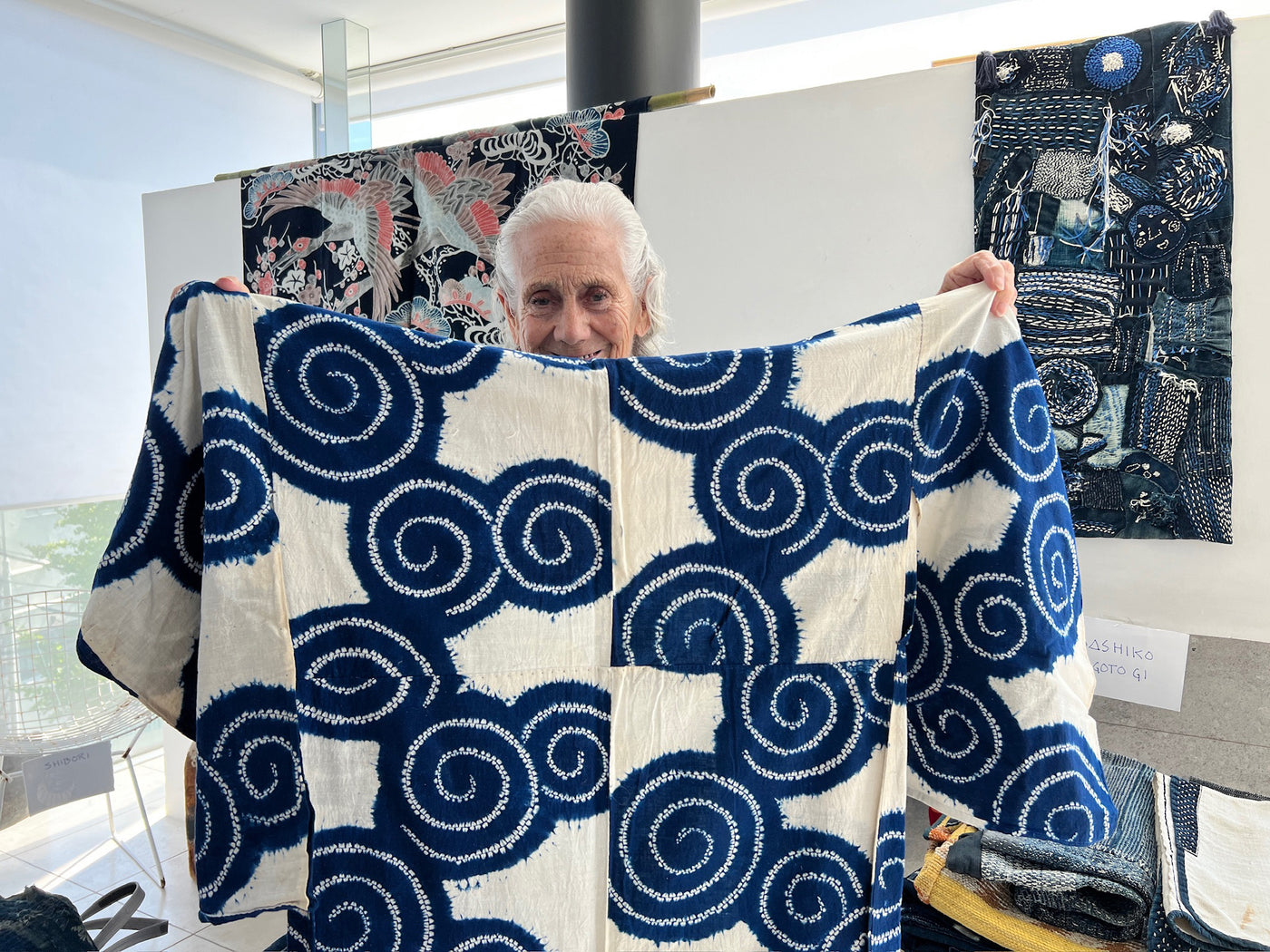 Amy Katoh displays textiles from her collection for the Okan Arts tour group